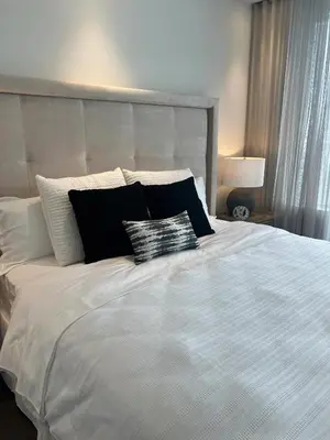 a bed with black and white pillows on it at INFIVILLA King Suites & Towers Eaton Toronto in Toronto
