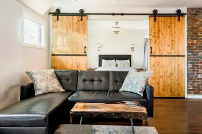 a living room with a couch and a bed at Stylishly Remodeled Queen Victoria Loft in Niagara Falls