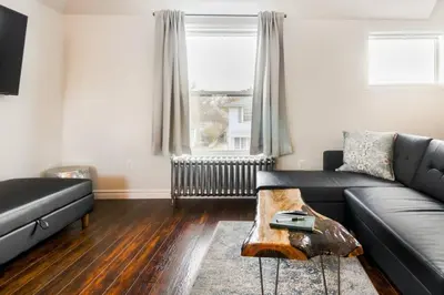 a living room with a couch and a table at Stylishly Remodeled Queen Victoria Loft in Niagara Falls