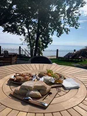 a wooden table with a plate of food on it at Crystal Beach Executive Waterfront Lakehouse in Fort Erie