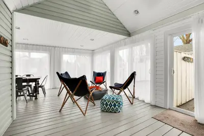 a screened in porch with chairs and a table at Family friendly Getaway Steps to the beach in Fort Erie