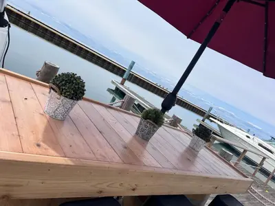 a wooden table with three potted plants and an umbrella at Bobs Yer Uncle in Port Dalhousie in St. Catharines