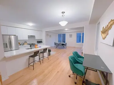 a kitchen and living room with a table and chairs at Vantage stay Modern 4BR townhouse pickering in Pickering