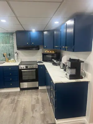 a kitchen with blue cabinets and a counter top at Modern & Cozy Basement Suite Lower Unit - 3 rooms -1 King bed - 2 Car Parking in Pickering