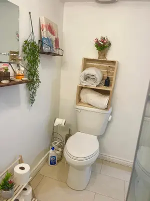 a bathroom with a toilet with shelves on the wall at Modern & Cozy Basement Suite Lower Unit - 3 rooms -1 King bed - 2 Car Parking in Pickering