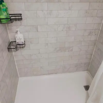 a bathroom with a white tiled shower with a soap dispenser at TORONTO BLUE JAYS- World Cup Stay in Toronto