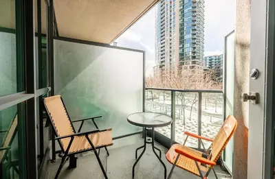 a balcony with chairs and a table and a window at 1 Bedroom plus Den Condo Garden View Fort York Downtown Toronto in Toronto