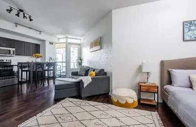 a living room with a couch and a dining room at 1 Bedroom plus Den Condo Garden View Fort York Downtown Toronto in Toronto
