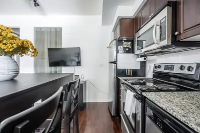 a kitchen with a stove and a counter top at 1 Bedroom plus Den Condo Garden View Fort York Downtown Toronto in Toronto