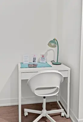 a white desk with a lamp and a white chair at Modern Studio Condo Yonge Street Downtown Toronto in Toronto