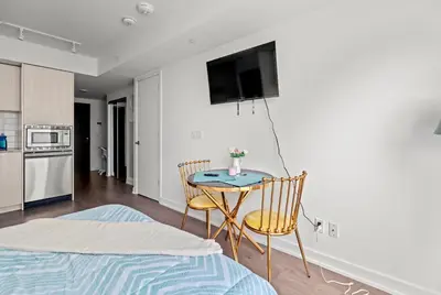 a room with a table and a tv on the wall at Modern Studio Condo Yonge Street Downtown Toronto in Toronto