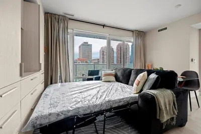 a bedroom with a bed and a large window at Panoramic 2 Bedroom plus Den Condo Yonge Street Downtown Toronto in Toronto