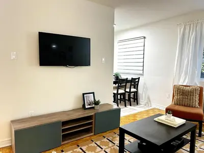 a living room with a flat screen tv on the wall at Toronto Upper Beaches Apartment in Toronto