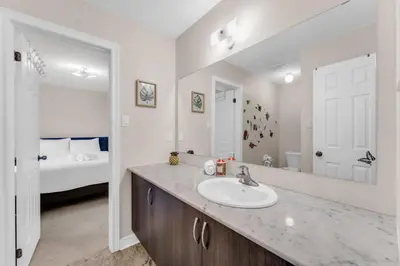 a bathroom with a sink and a bedroom with a bed at Luxury Home Mins from Waterfall next to Transit in Niagara Falls
