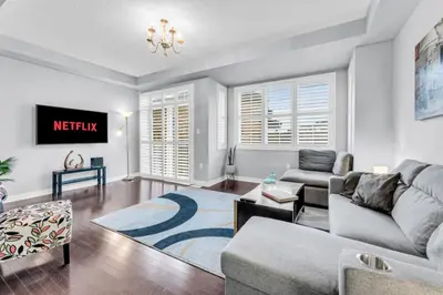 a living room with a couch and a tv at Charming Home with Airport and Toronto Nearby in Brampton