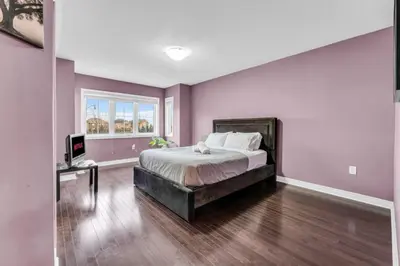 a bedroom with a large bed and a window at Charming Home with Airport and Toronto Nearby in Brampton