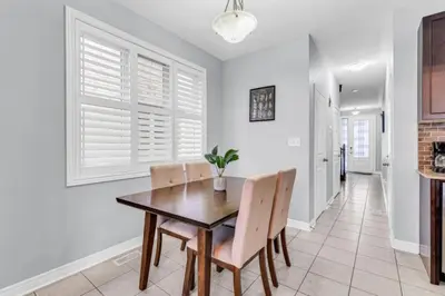a dining room with a wooden table and chairs at Charming Home with Airport and Toronto Nearby in Brampton