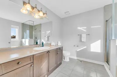 a bathroom with a sink and a toilet and a mirror at Cozy Home in Niagara 10 mins from Falls and Brock in Thorold