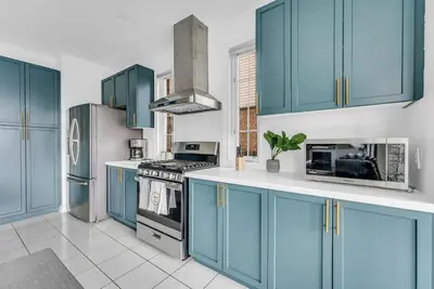 a kitchen with blue cabinets and a stove and refrigerator at Luxury Mansion with Chefs Kitchen by Niagara Falls in Thorold