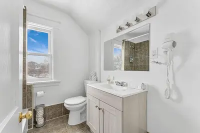 a white bathroom with a sink and a toilet at Pristine Home 5 min walk to Clifton Hill in Niagara Falls