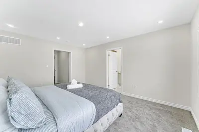 a white bedroom with a large bed in it at Designer Home in Niagara Falls in Thorold