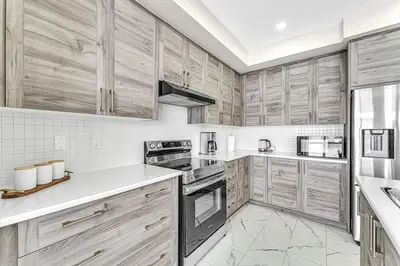 a large kitchen with wooden cabinets and appliances at Designer Home in Niagara Falls in Thorold