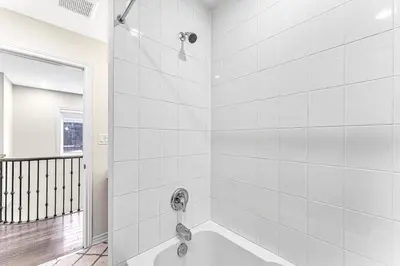 a white bathroom with a tub and a shower at Designer Home in Niagara Falls in Thorold