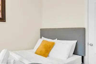 a bed with white pillows and a yellow pillow at Sunshine Villa Closest BNB to Falls Hot Tub Oasis in Niagara Falls