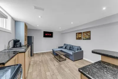 a living room with a couch and a kitchen at Spacious 6BR Getaway Sleeps 16 Yard and Parking in Brampton