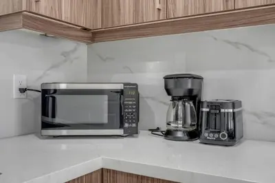 a kitchen counter with a microwave and a coffee maker at Spacious 6BR Getaway Sleeps 16 Yard and Parking in Brampton