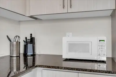 a kitchen with a white microwave above a kitchen counter at Bright and Stylish Family Home Near Niagara Falls in Thorold
