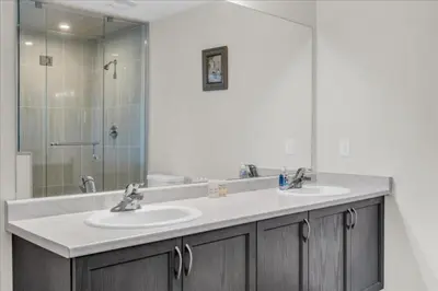 a bathroom with two sinks and a shower at Bright and Stylish Family Home Near Niagara Falls in Thorold