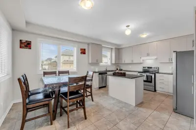 a kitchen with a table and chairs in a room at Bright and Stylish Family Home Near Niagara Falls in Thorold