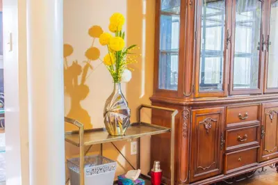 a vase with flowers on a table next to a cabinet at Royal Luxury Central Home with Gazebo By Toronto in Brampton