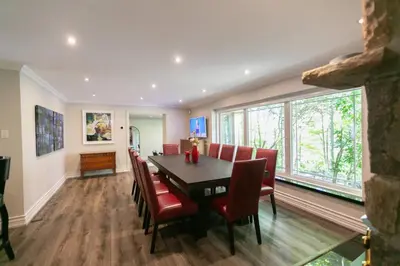 a dining room with a table and red chairs at Luxury 4BR Stay with Swim Spa, Golf and Fireplaces in Caledon