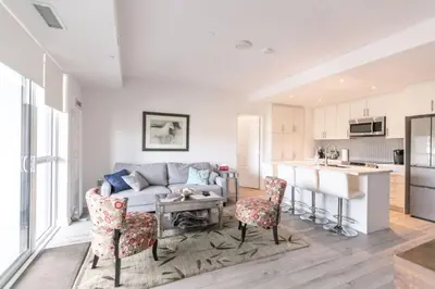 a living room with a couch and a table and chairs at Modern 2BR Getaway with Balcony, BBQ and Parking in Innisfil