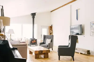 a living room with a couch and chairs and a fireplace at Wellington Waterfront Home in Wellington