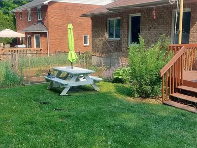 a picnic table with a yellow umbrella in a yard at White Rolling Sands of Penetang by Theatre in Penetanguishene