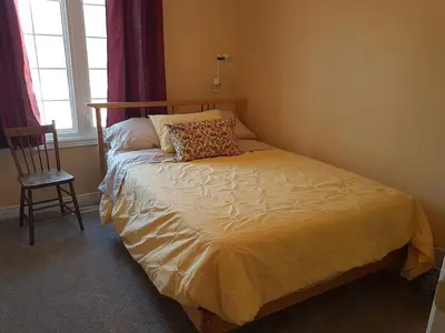 a bedroom with a bed with a pillow and a chair at White Rolling Sands of Penetang by Theatre in Penetanguishene
