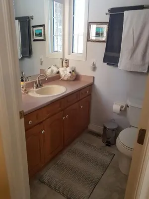 a bathroom with a sink and a toilet and a window at White Rolling Sands of Penetang by Theatre in Penetanguishene