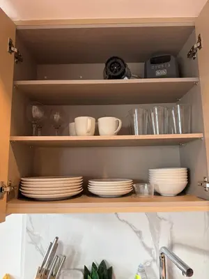 a kitchen shelf with plates and dishes on it at Entire Luxe Condo in Downtown Toronto in Toronto