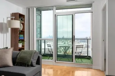 a living room with sliding glass doors with a table at Stunning 1BD Lakeview Condo near BMO Free Parking in Toronto