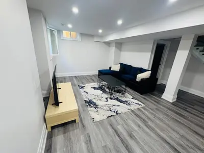 a living room with a couch and a table at Hearth & Home Spacious Suite in Pickering
