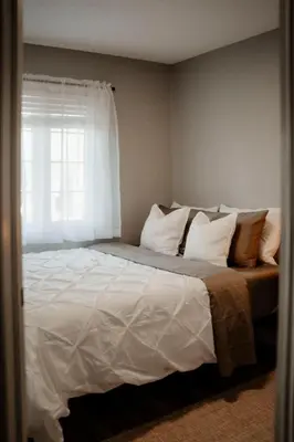 a bedroom with a large white bed with a window at Barrie Hideaway in Barrie