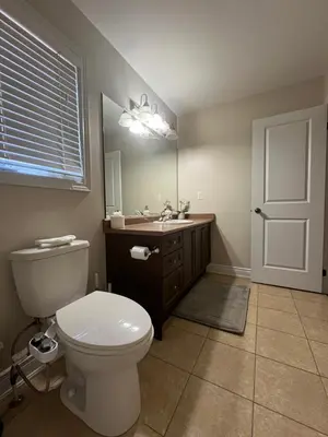 a bathroom with a toilet and a sink and a mirror at 3300 SqFt - Modern and Comfort - 3 BDRM Getaway - Relax - Unwind - Explore - Near Toronto Pearson Airport & Toronto Downtown in Brampton