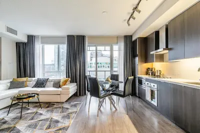 a living room with a couch and a table at Modern 1 Bedroom Condo Front Street Downtown Toronto in Toronto