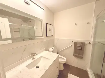 a white bathroom with a sink and a toilet at Modern 1-BR Suite EV Charger, Backyard BBQ & Near Square One in Mississauga