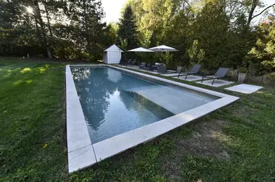 a swimming pool in a yard with chairs and umbrellas at Luxury Countryside Villa in Waterford