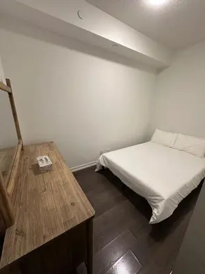 a bedroom with a bed and a wooden table at Cozy Condo Midtown Toronto in Toronto