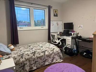 a bedroom with a bed and a desk with a computer at Home in Scarborough, near GO station, TTC and UoT in Toronto